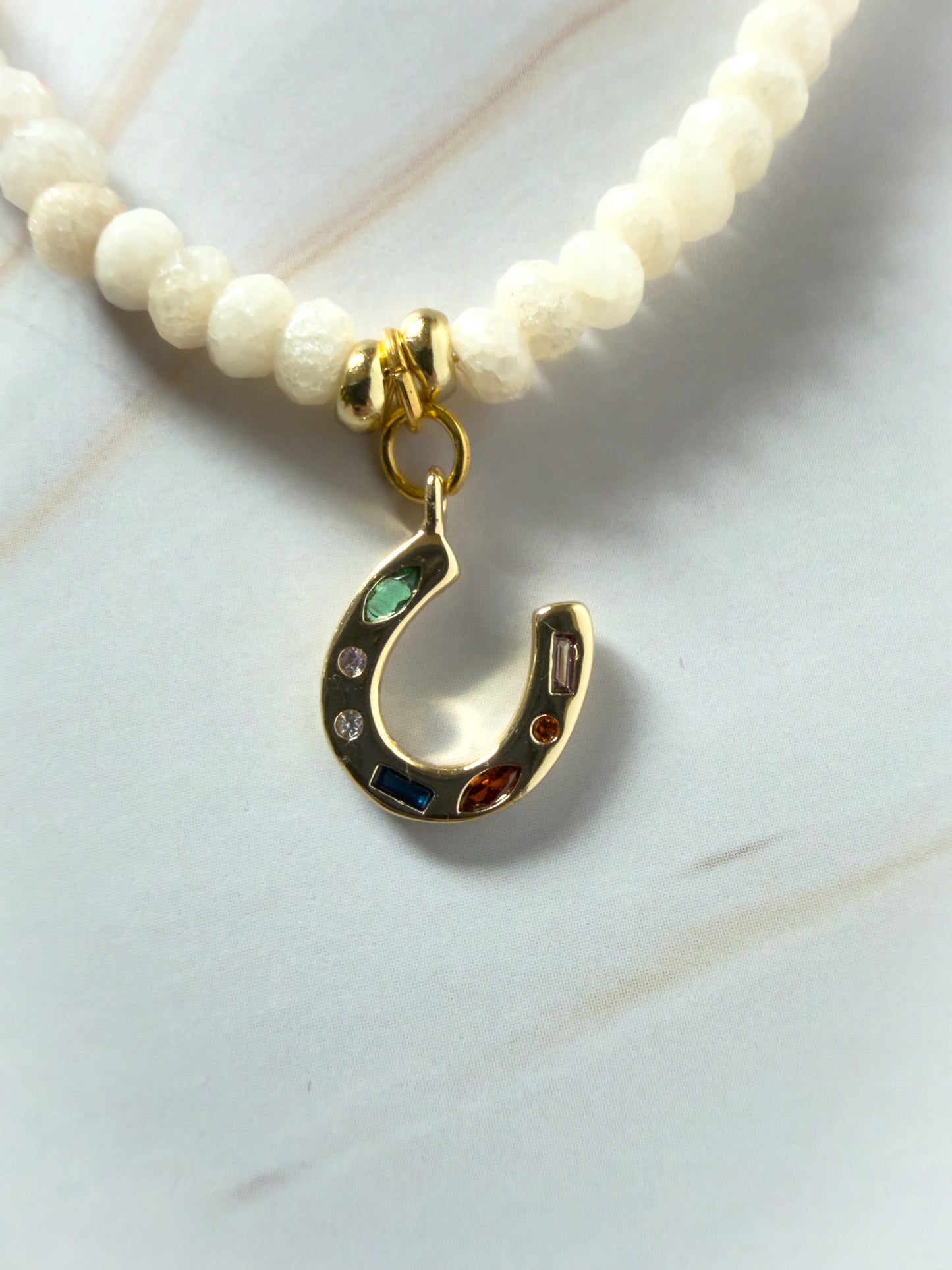 Necklace with a gold horseshoe charm on a white background