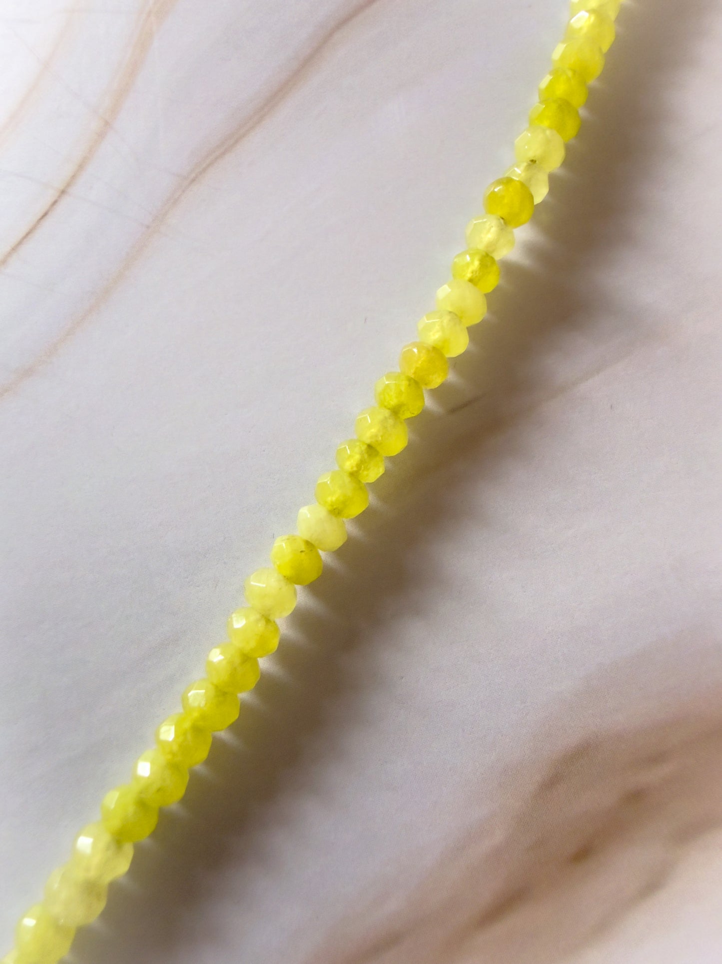 Close-up of a string of yellow beads on a light background