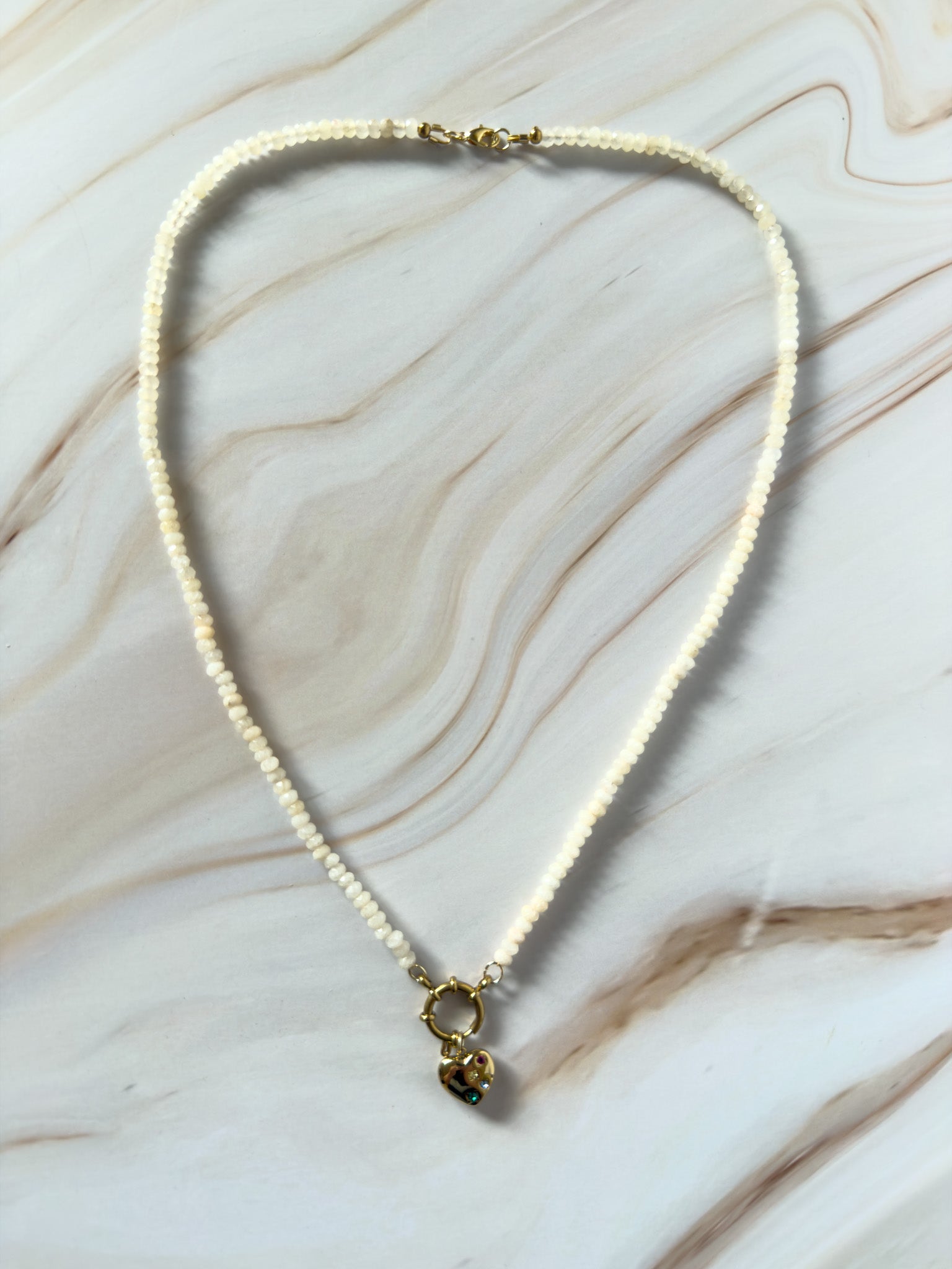 Necklace with a heart-shaped pendant on a marble surface