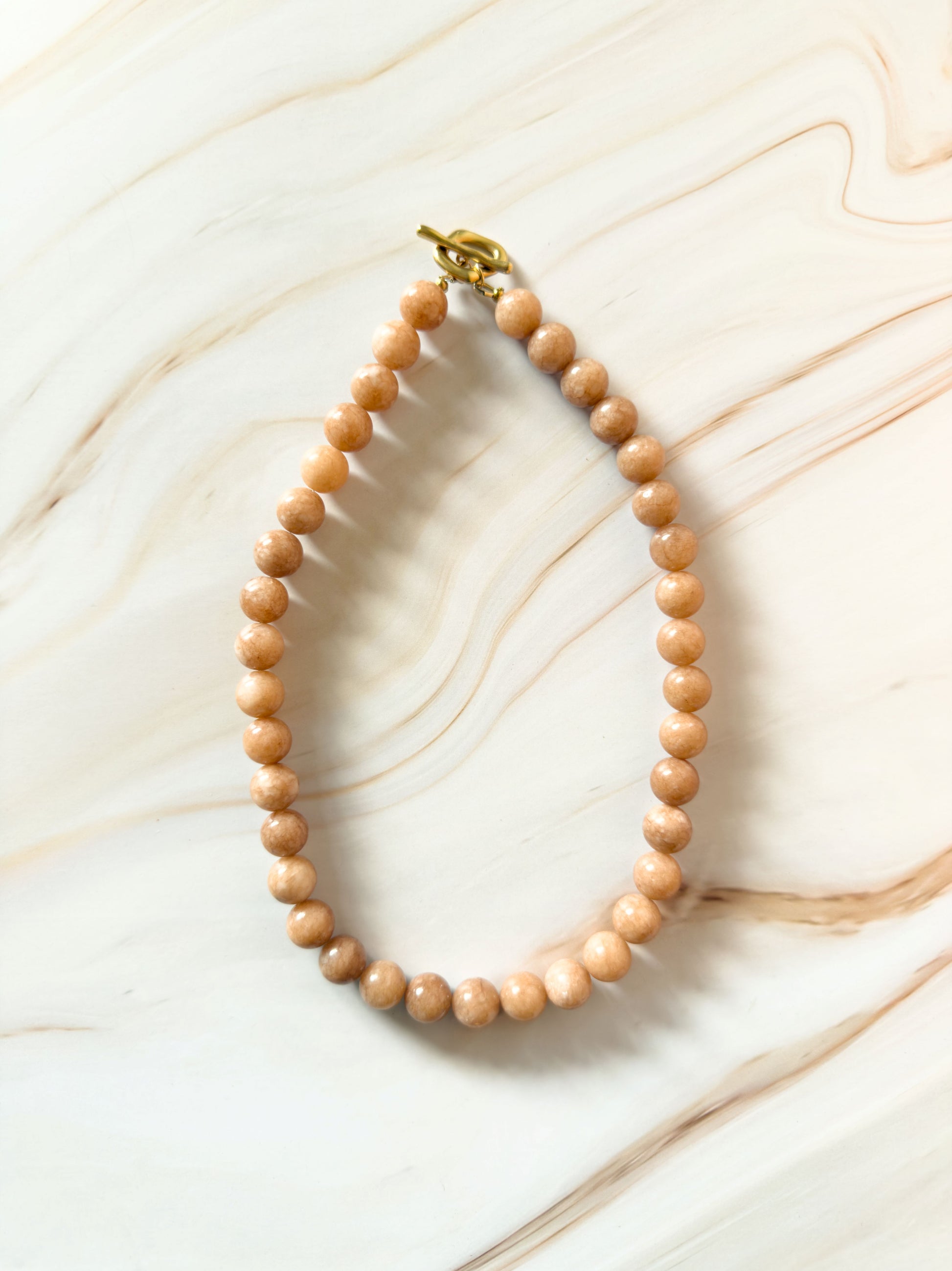 Stone beaded necklace on a marble surface