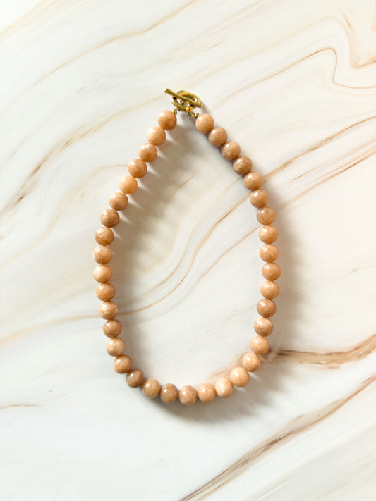 Stone beaded necklace on a marble surface