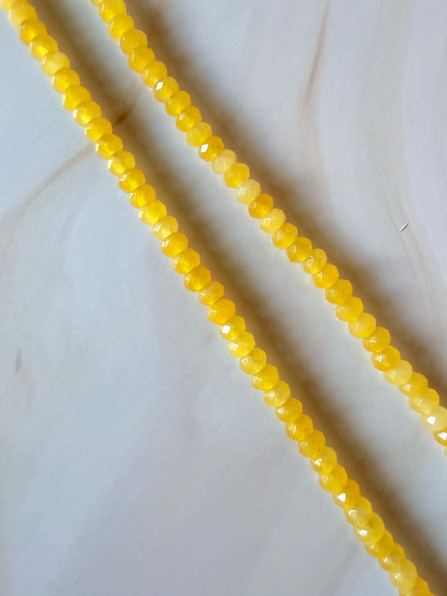 Handmade yellow bead necklace on a white background